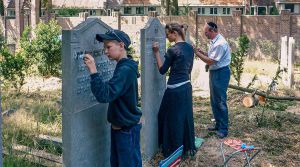 Jong en oud aan het werk op een Joodse begraafplaats.