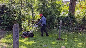 Vrijwilliger aan het werk op begraafplaats.